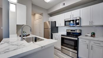 Modern kitchen with white cabinets and stainless appliances